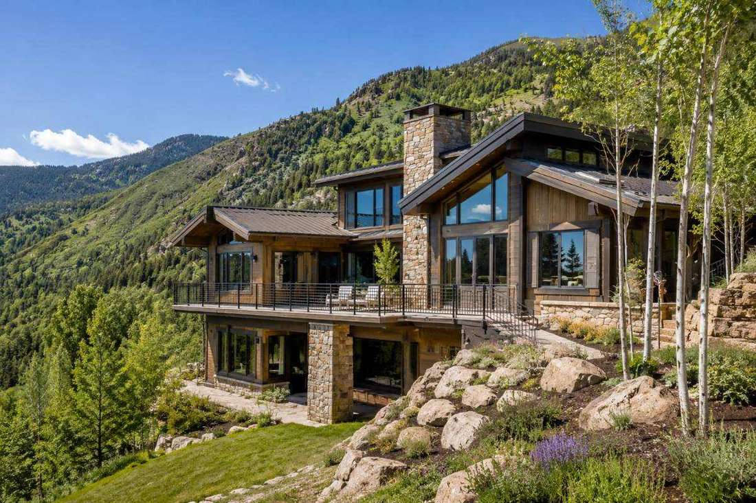 Hillside Aspen-area home with a walkout lower level, mountains behind